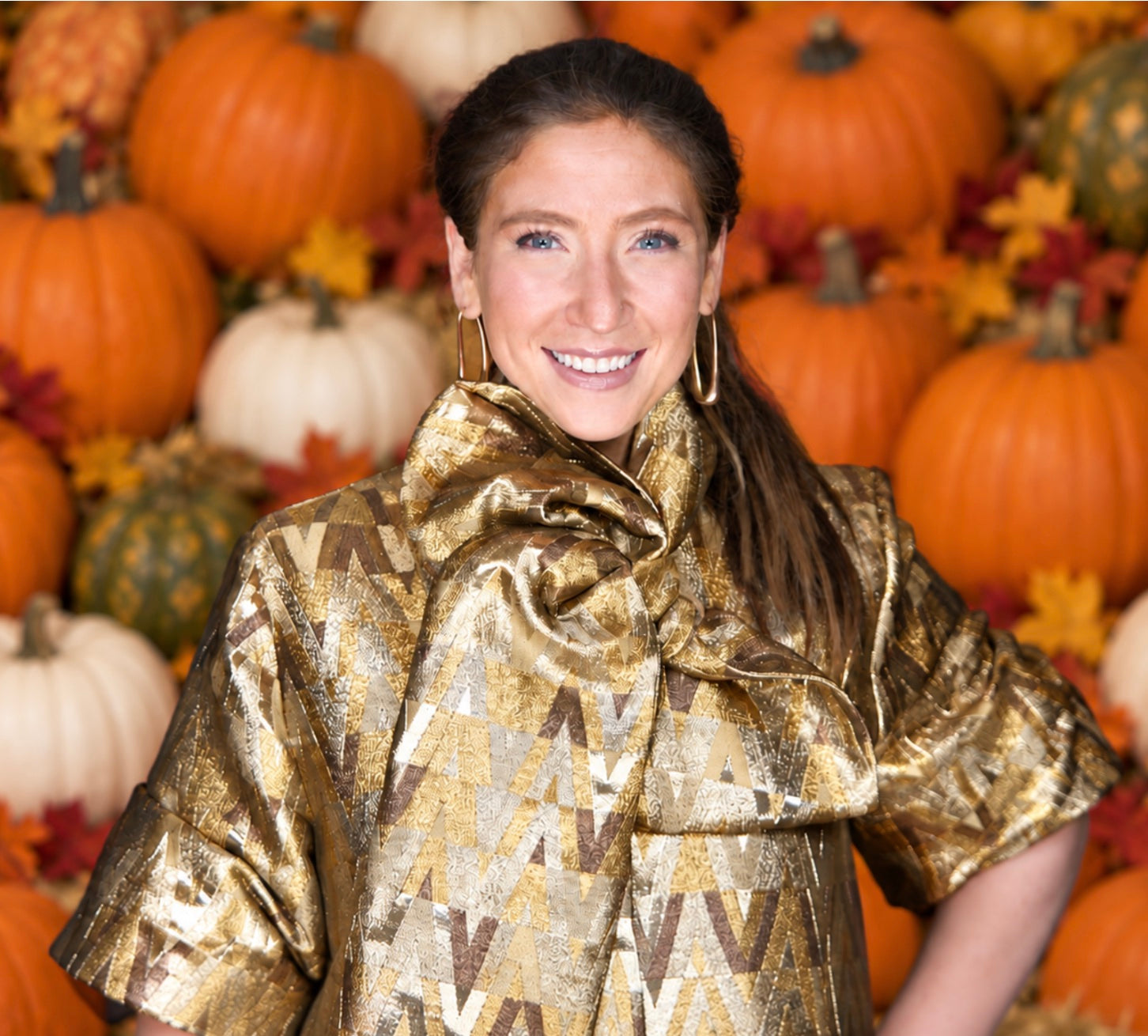 Dvorah Leah, founder of Stooped, in front of a seasonal pumpkin display